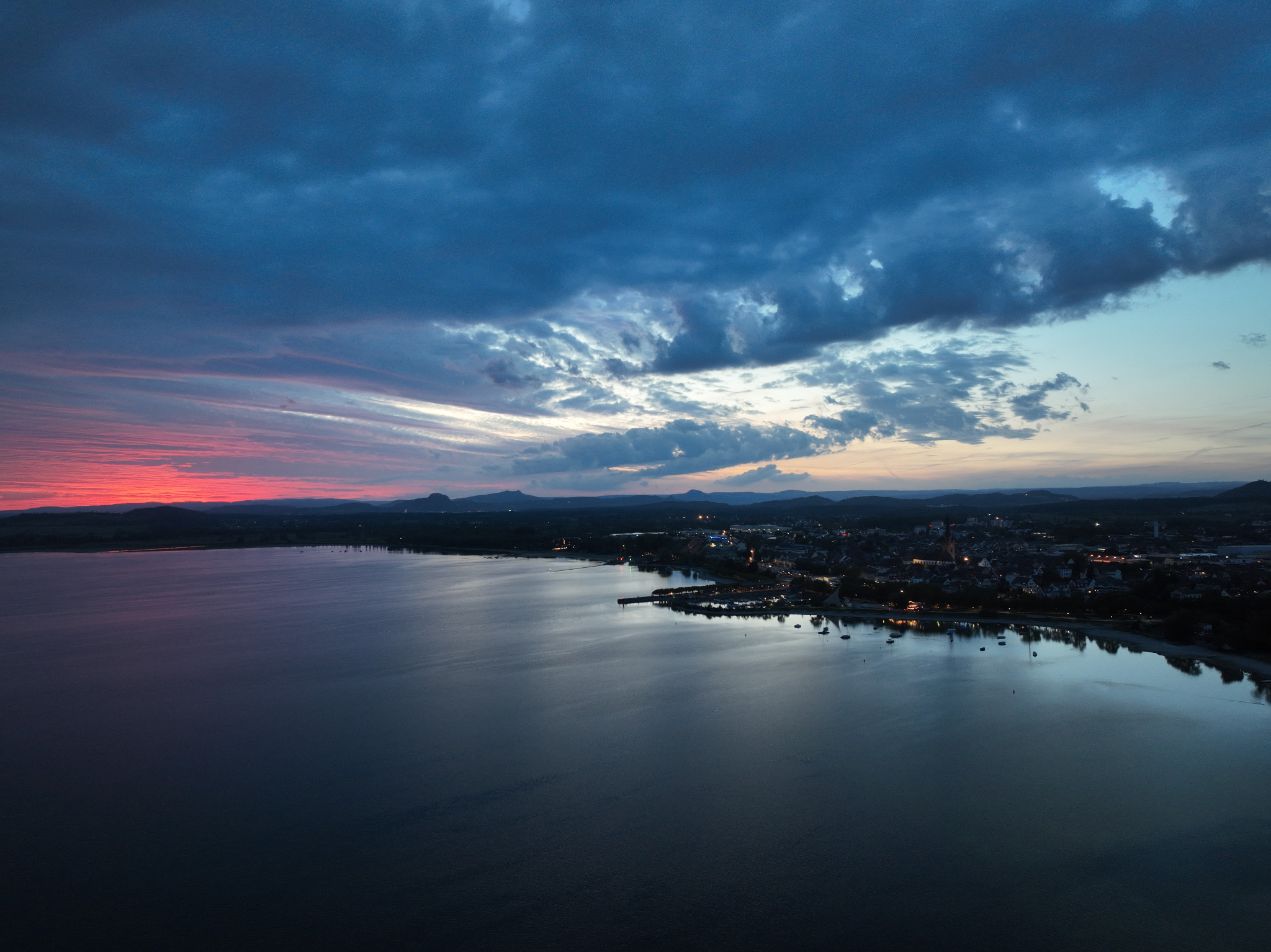 Dunkle Luftaufnahme über dem Bodensee bei Sonnenuntergang